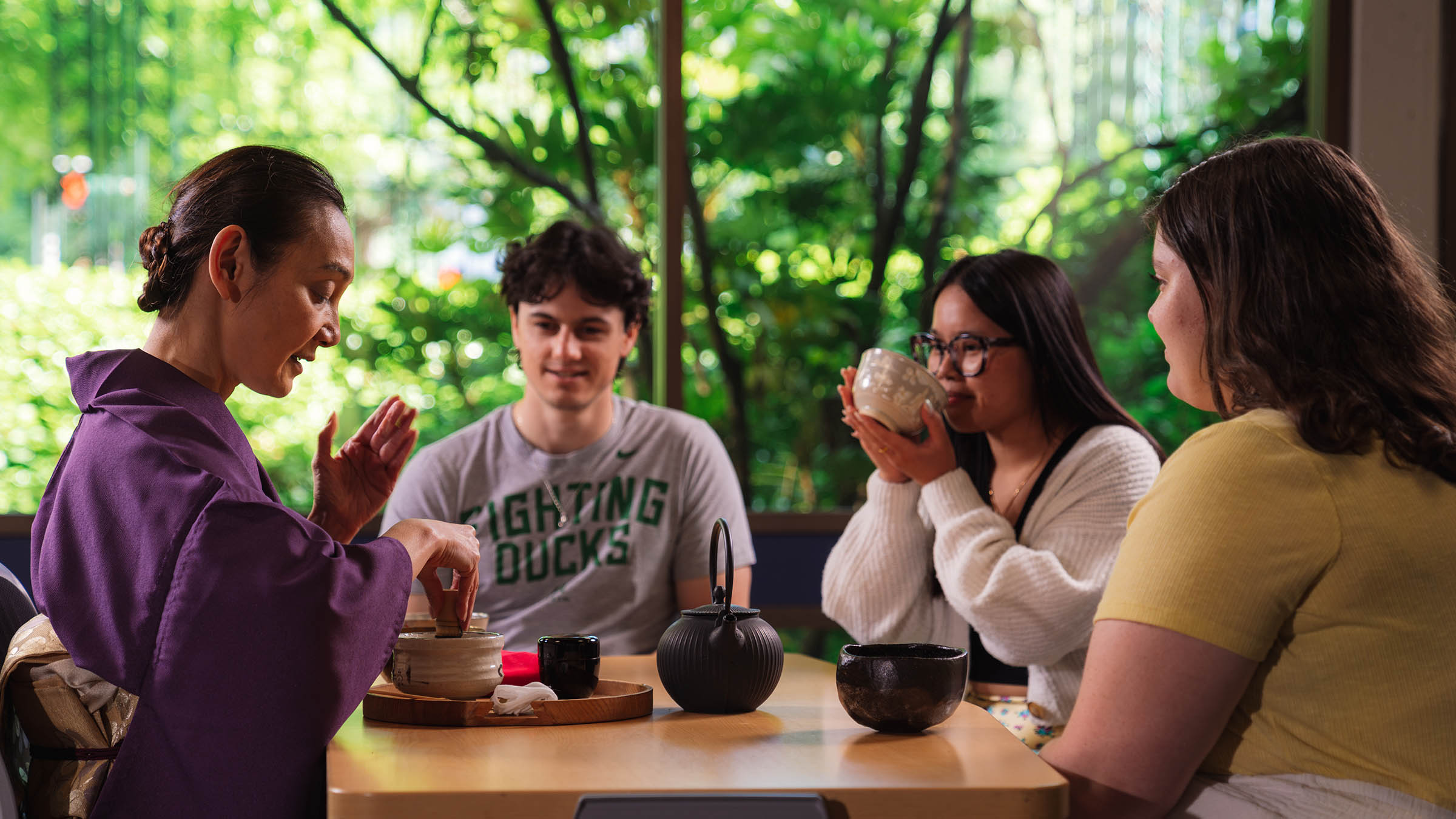 An instructor leads students through a traditional Japanese tea ceremony, demonstrating the preparation and serving while teaching cultural customs and etiquette