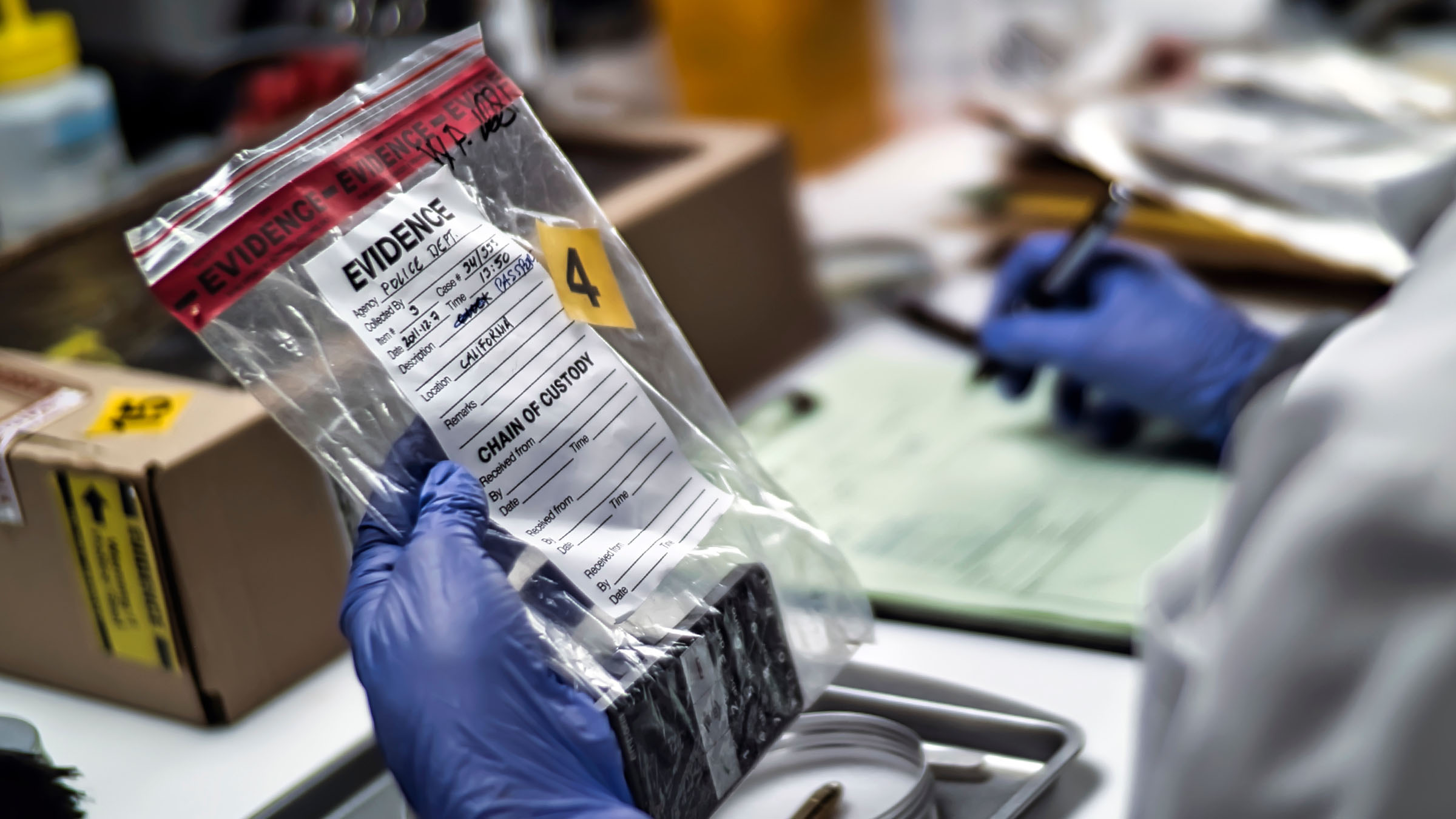 Student examining labeled evidence bag in a forensic laboratory