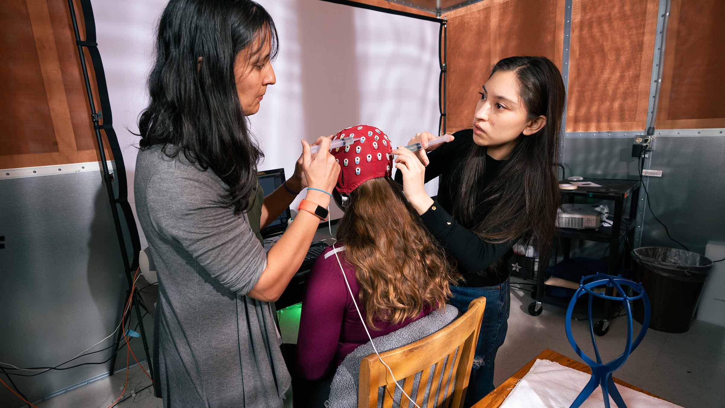 Researchers preparing electroencephalography (EEG) equipment to record brain activity during a neuroscience study