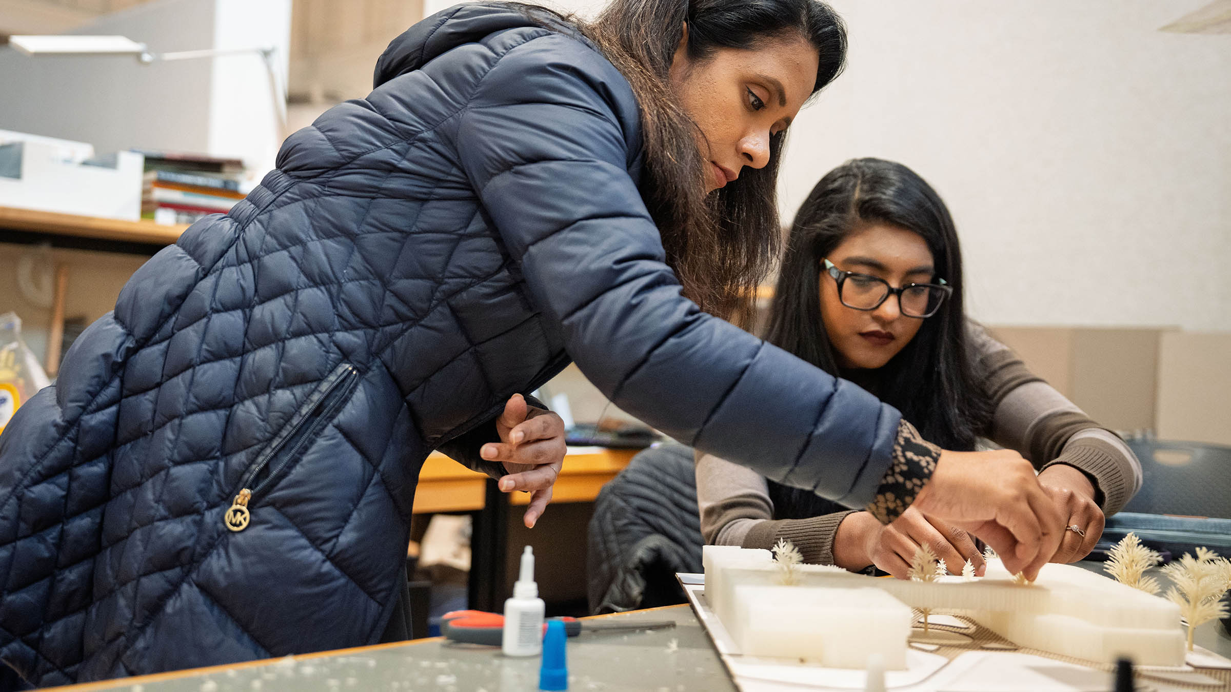 Student and faculty member reviewing and refining a scale architectural model