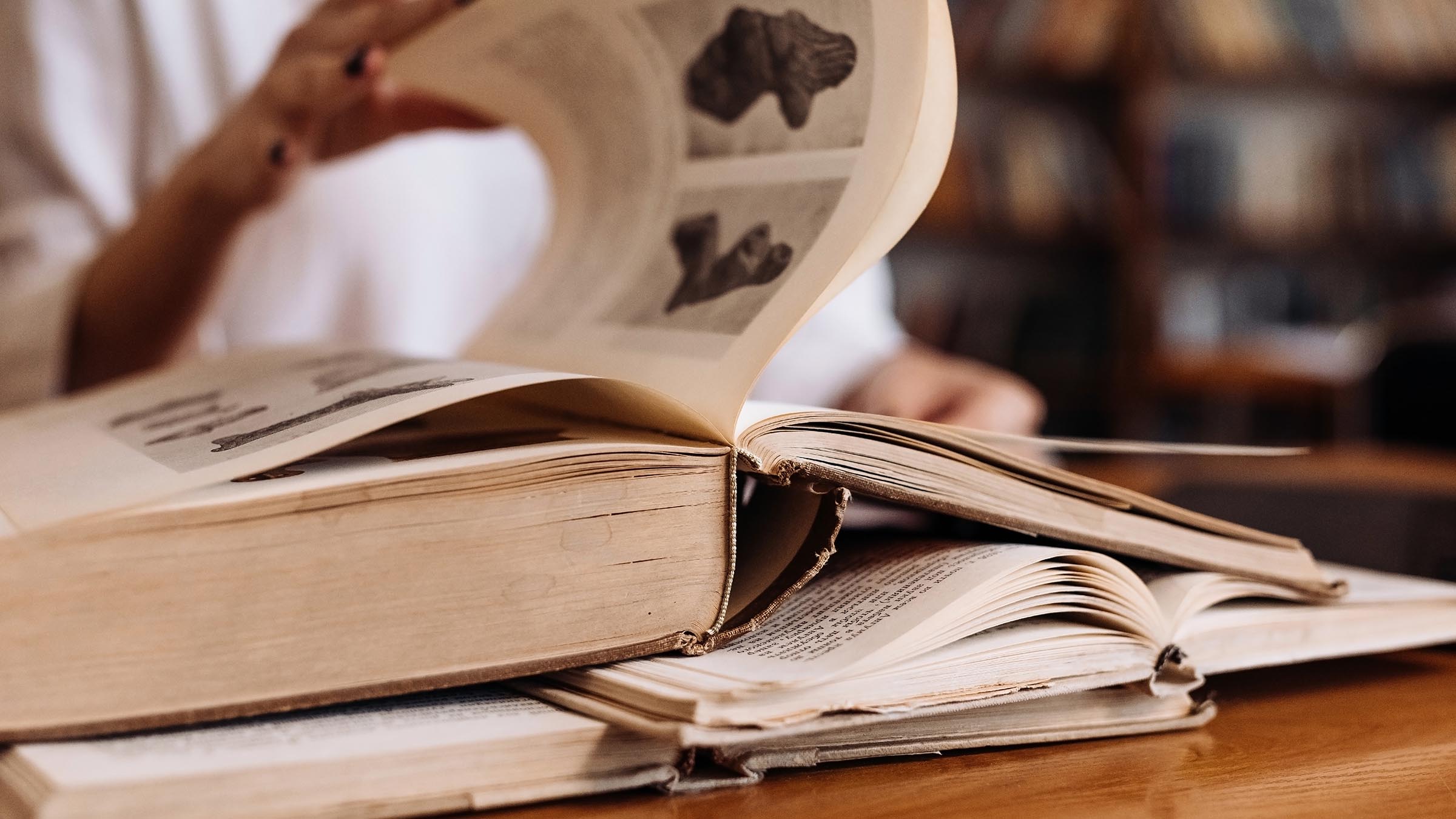 Student turning pages of a reference book