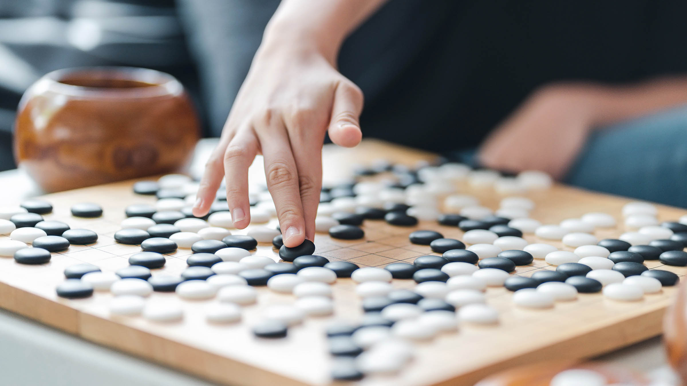 Close-up of a player making a move on a Go board