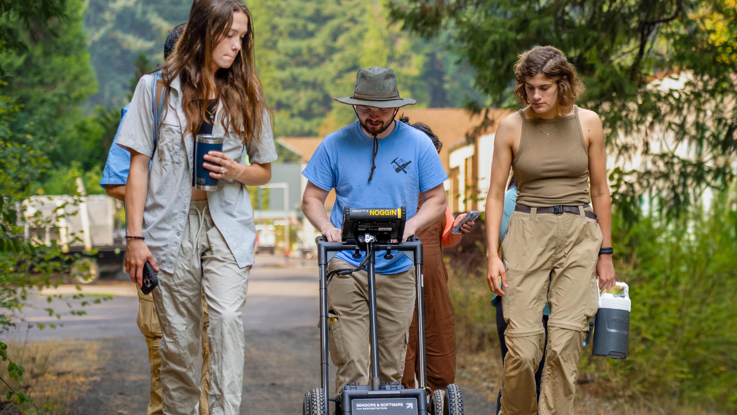 Students using ground-penetrating radar to map subsurface features during field research