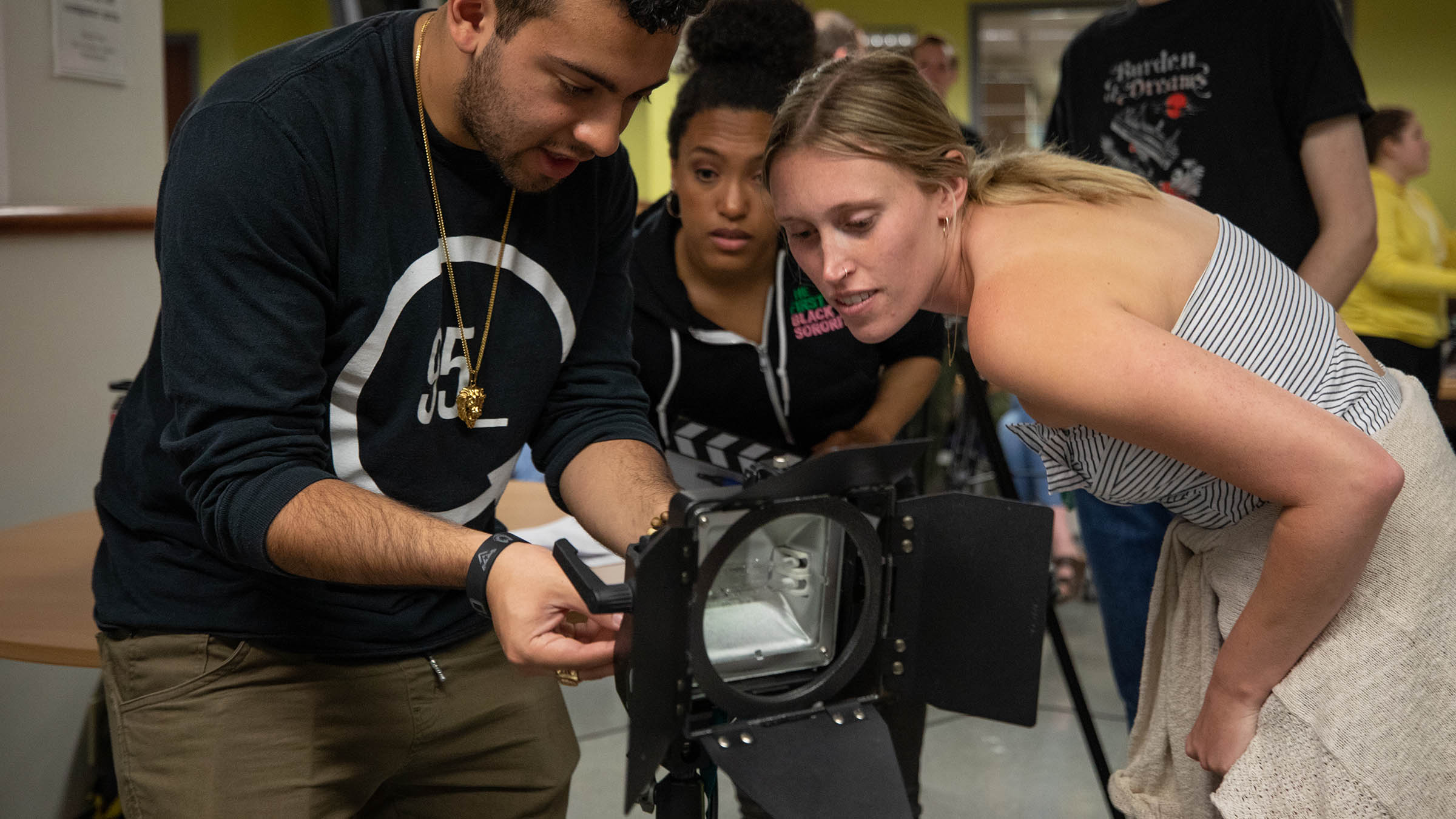 Students adjusting studio equipment during a hands-on cinema production class