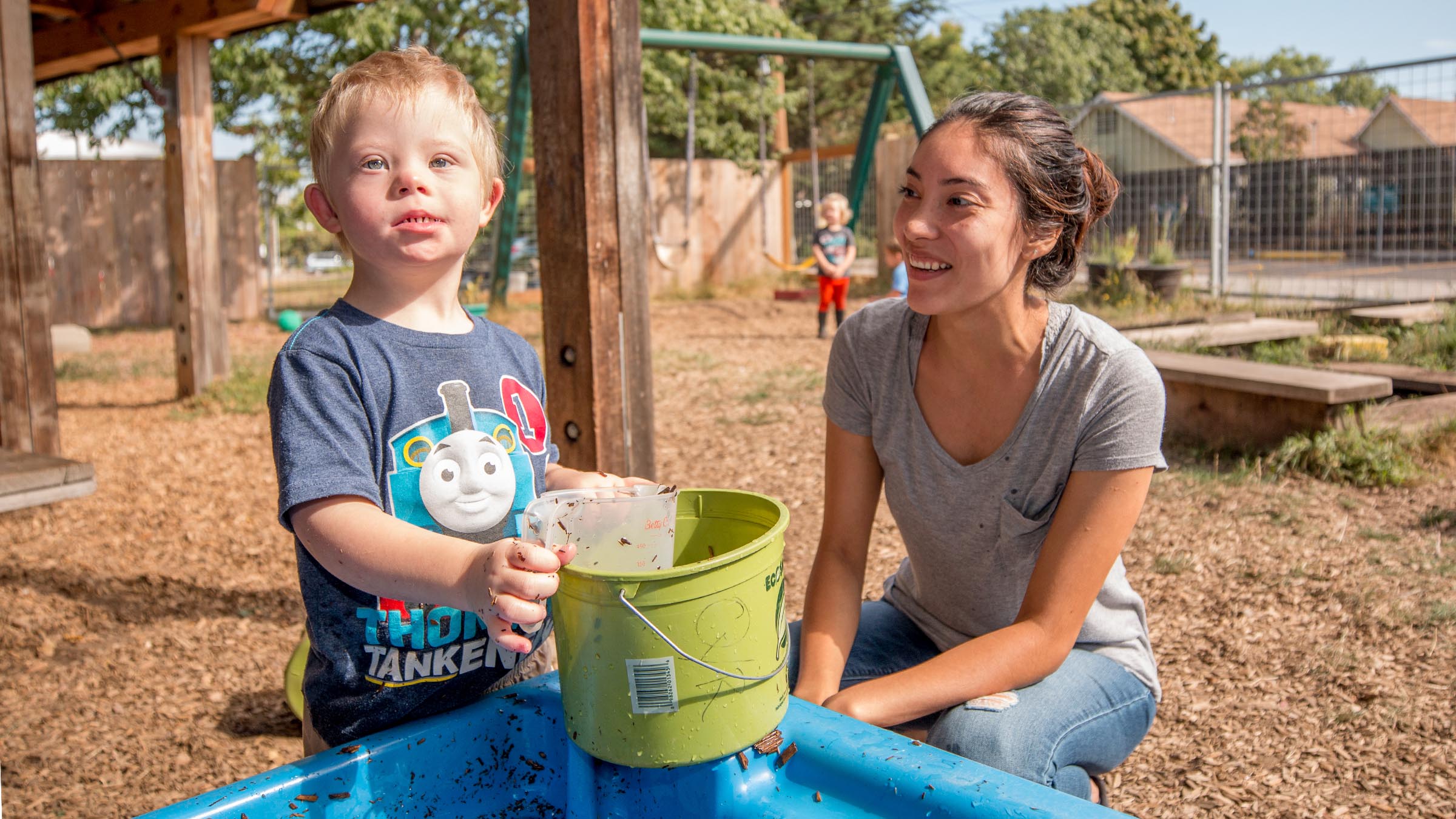 Student teacher working with child in the play area at Vivian Olum Child Development Center