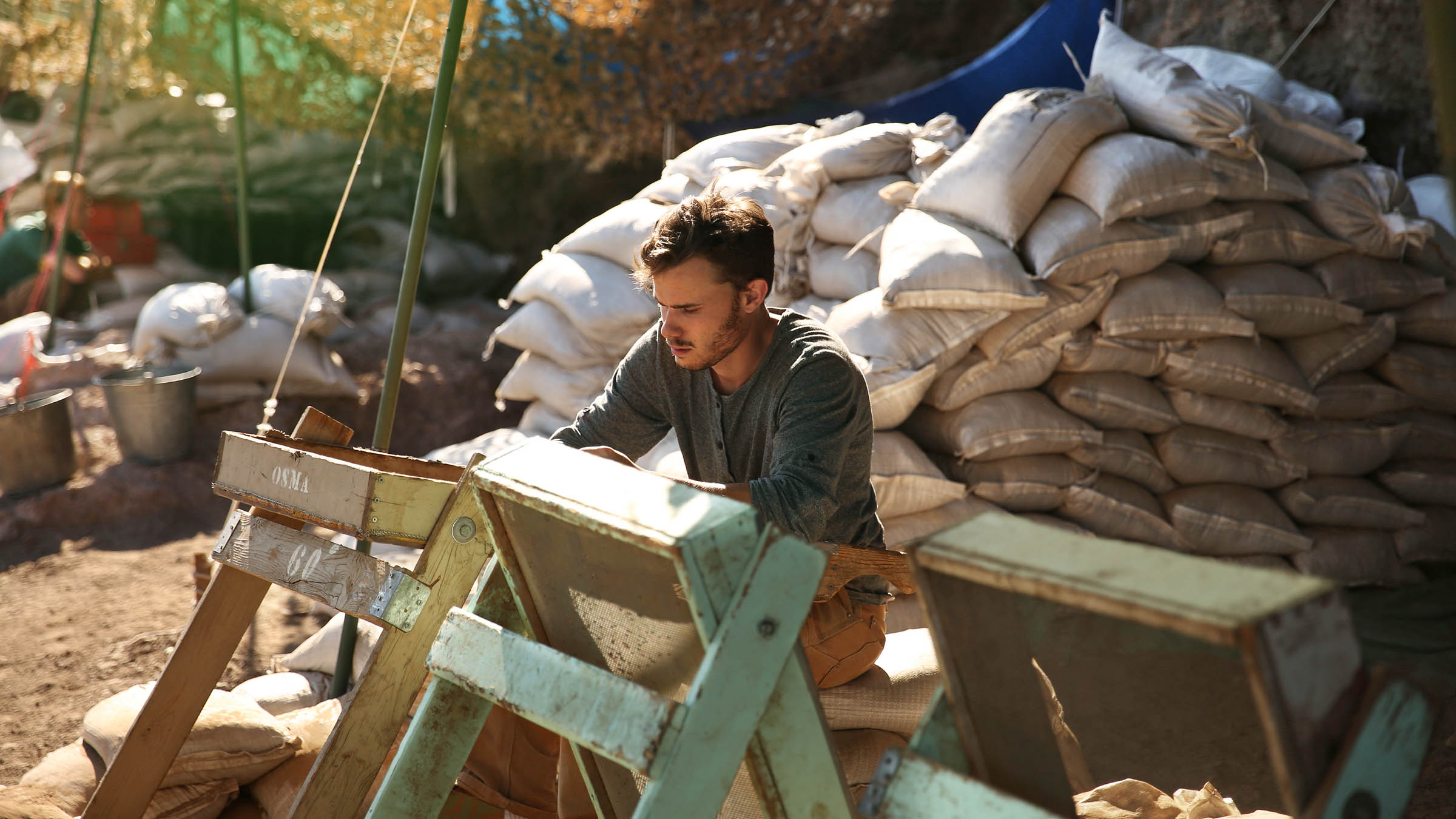 Student sifting soil at an excavation site to recover artifacts