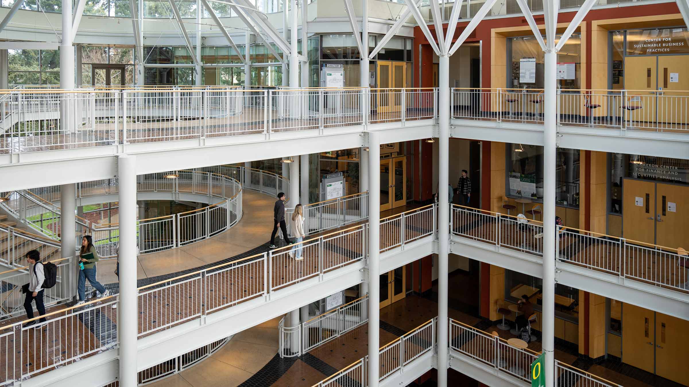 Light-filled atrium in the Lillis Business Complex with students walking through multiple levels of open corridors