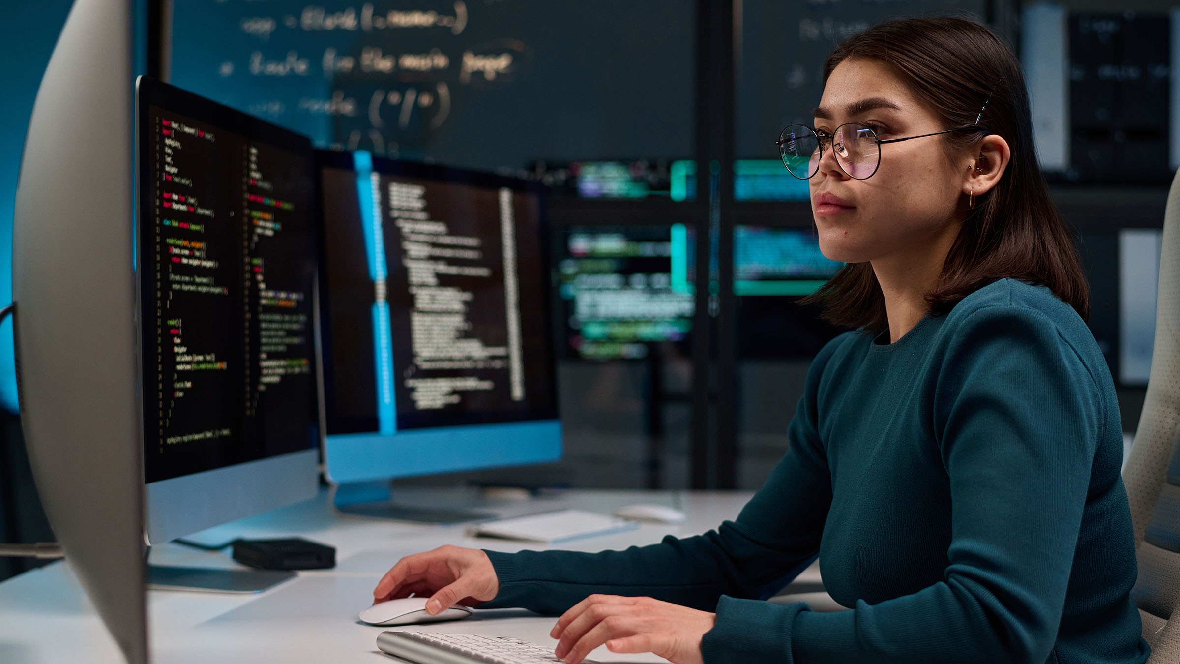 Student analyzes code on multiple monitors