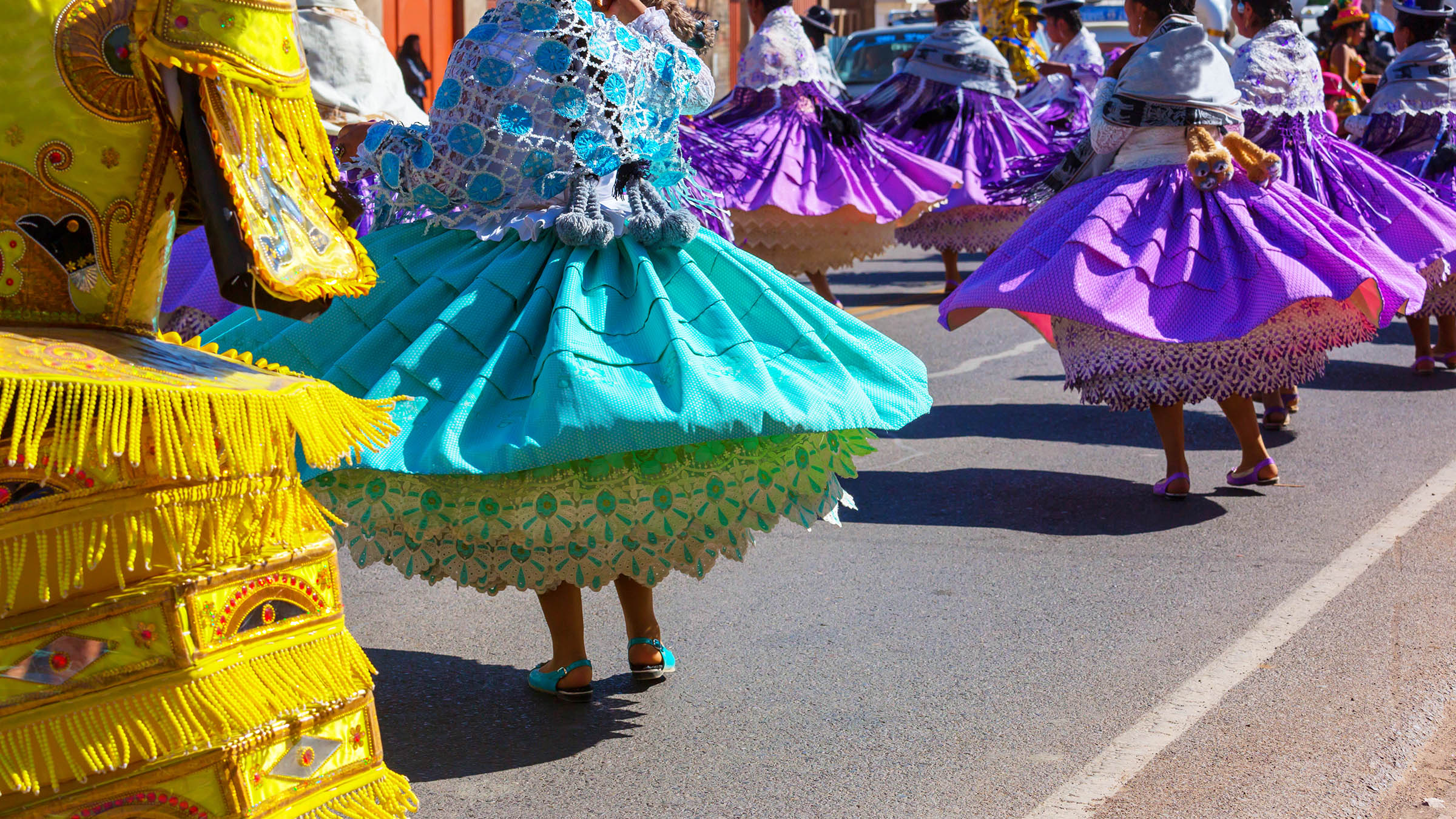 Performers in colorful traditional dress dancing at a celebration in Peru