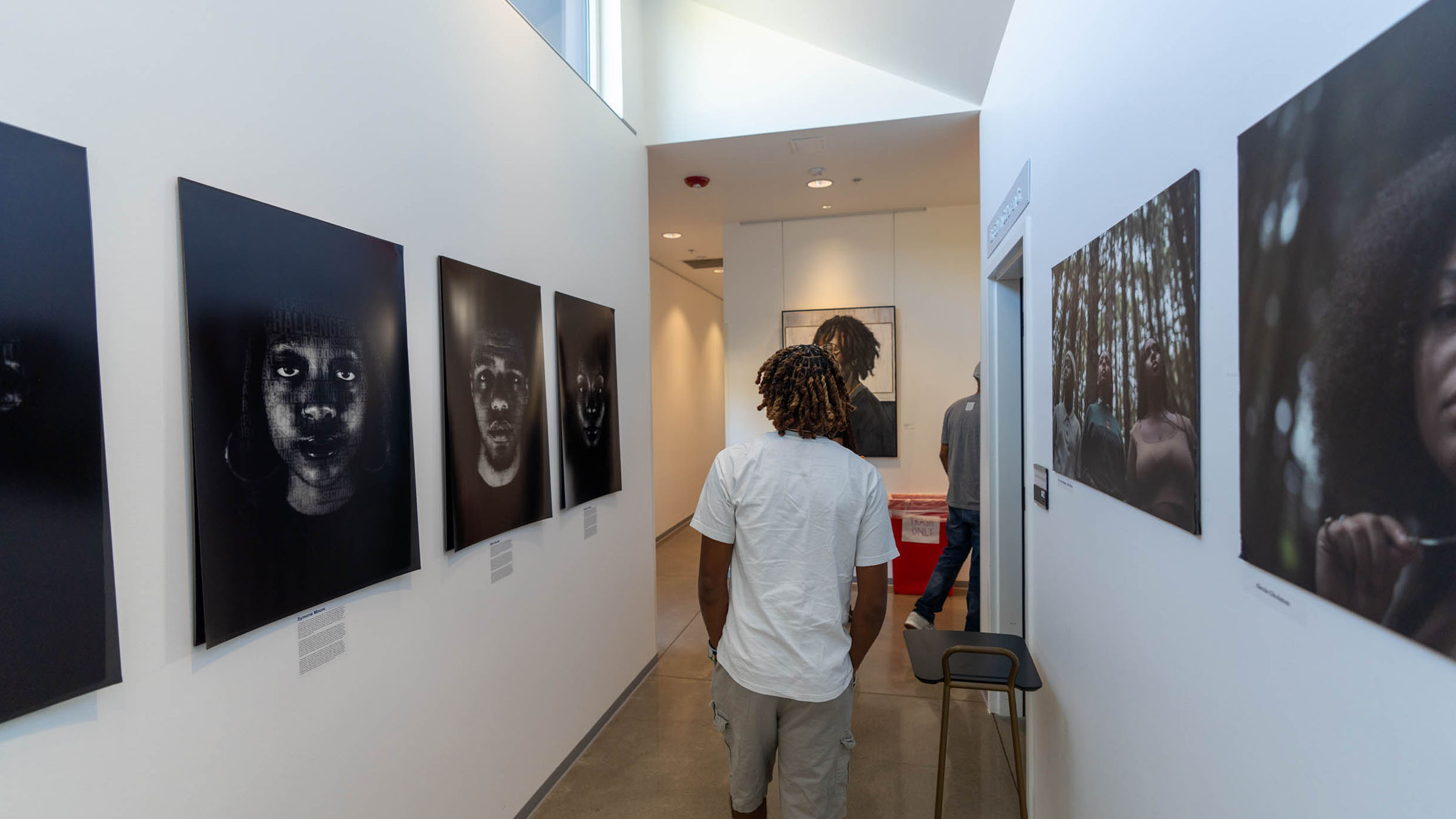 Student views portrait photography at a campus art exhibition