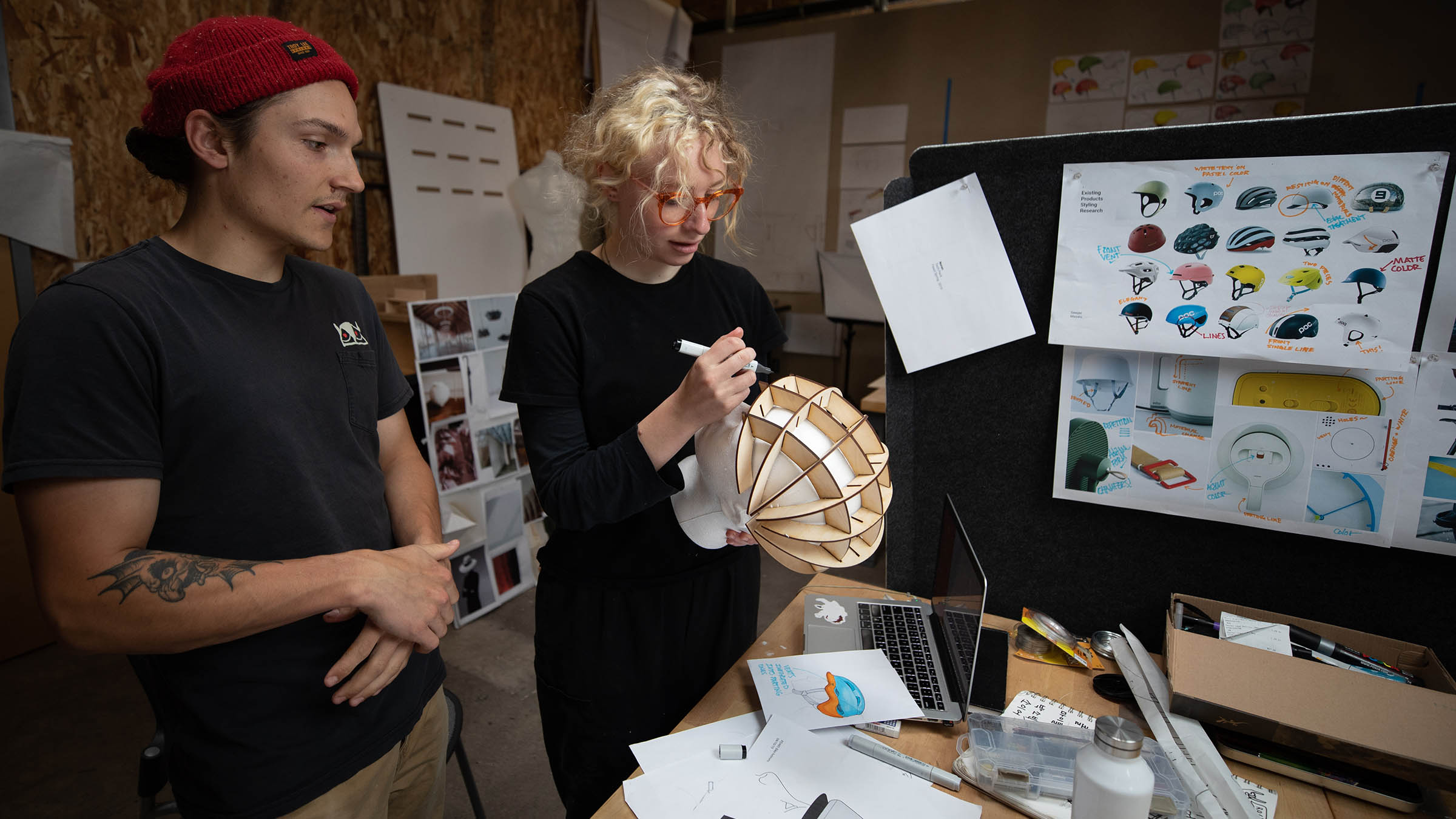 Students refining bicycle helmet concepts in a product design studio